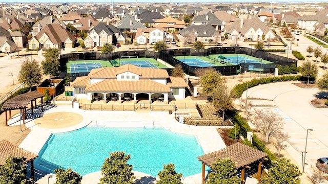 community pool with a patio area, a residential view, and fence