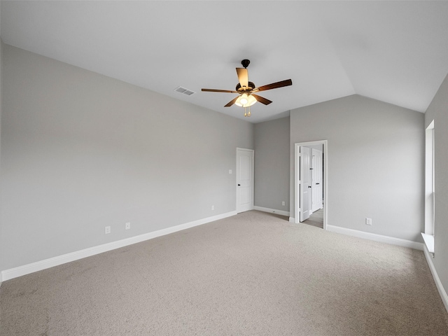 carpeted spare room with vaulted ceiling, baseboards, visible vents, and ceiling fan