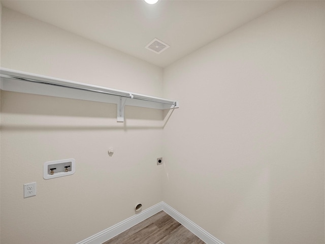 laundry room featuring electric dryer hookup, visible vents, washer hookup, light wood-style flooring, and laundry area