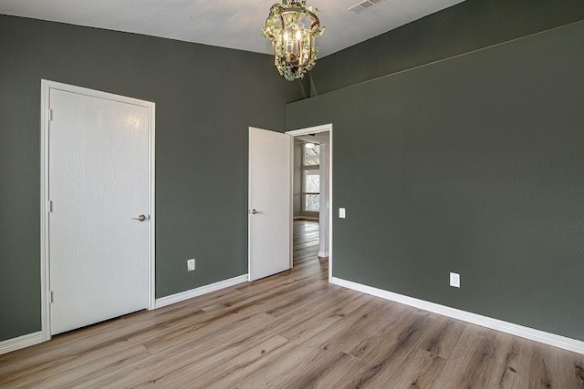 empty room with baseboards and wood finished floors