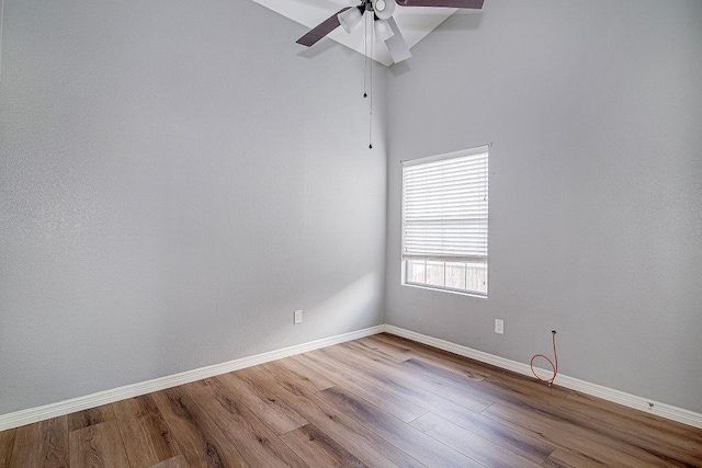 empty room featuring wood finished floors, baseboards, and ceiling fan