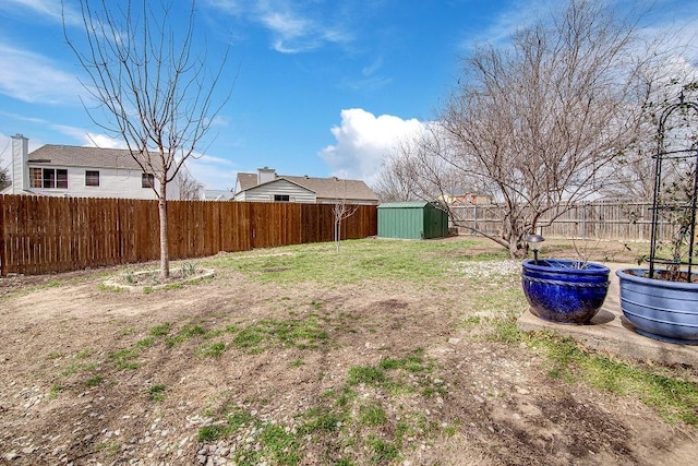 view of yard with a fenced backyard, a shed, and an outdoor structure