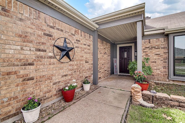 view of exterior entry with brick siding