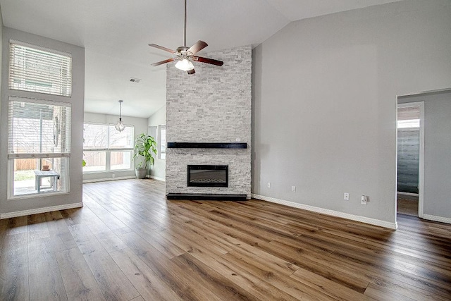 unfurnished living room featuring dark wood-style floors, a fireplace, high vaulted ceiling, and baseboards