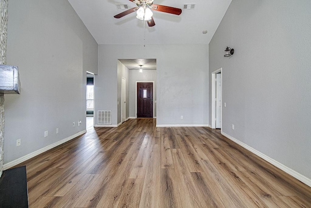 unfurnished living room featuring wood finished floors, visible vents, and baseboards