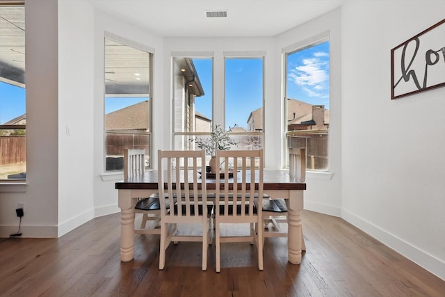 dining space with visible vents, plenty of natural light, baseboards, and wood finished floors