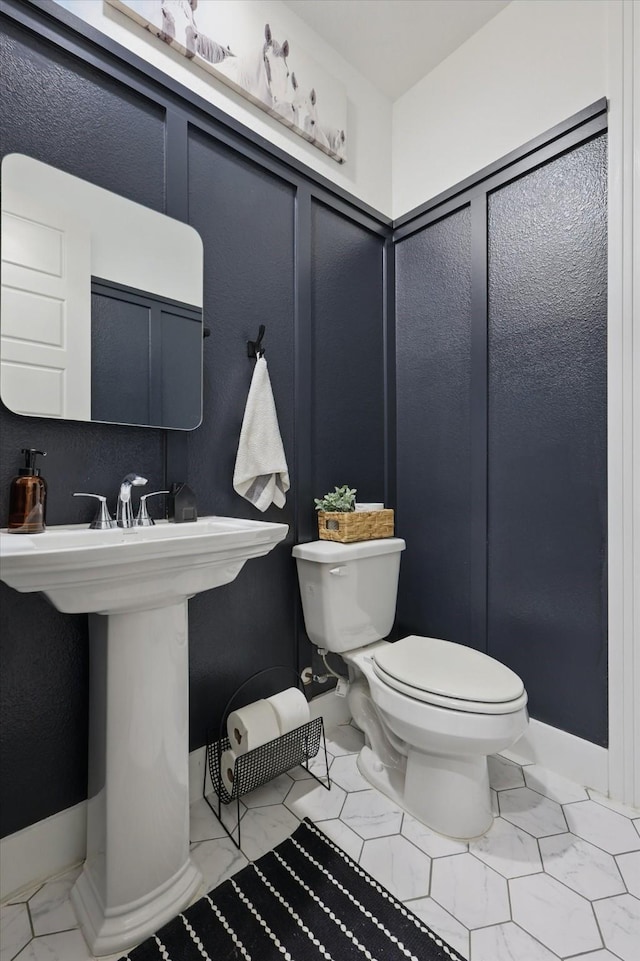 bathroom with baseboards and toilet