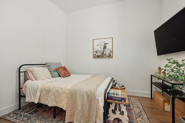 bedroom featuring baseboards and wood finished floors