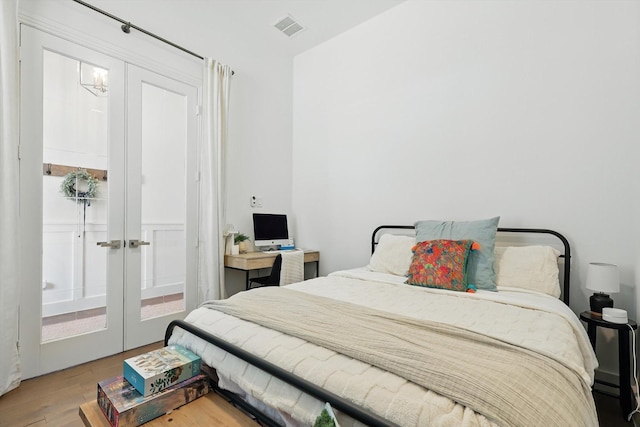 bedroom with visible vents, french doors, and wood finished floors