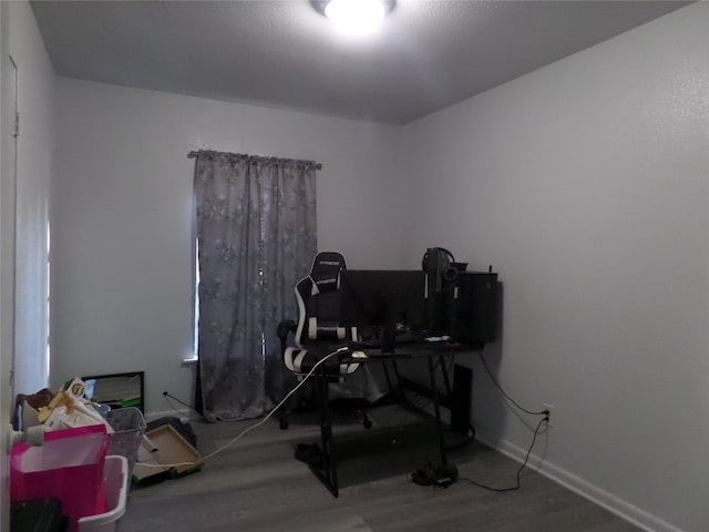 home office with baseboards and wood finished floors