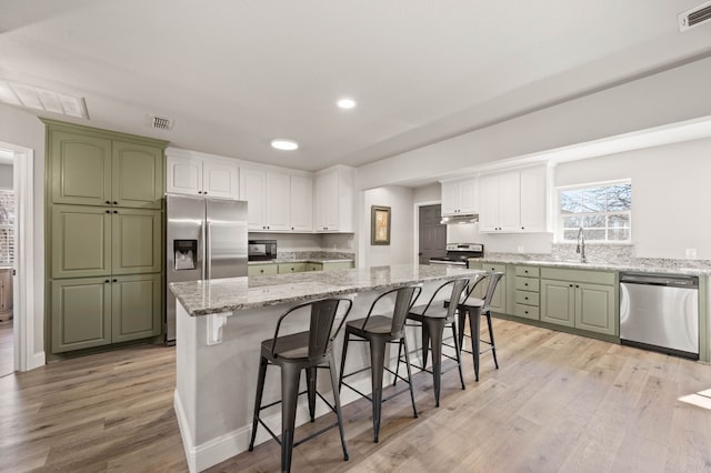 kitchen featuring green cabinetry, appliances with stainless steel finishes, and visible vents