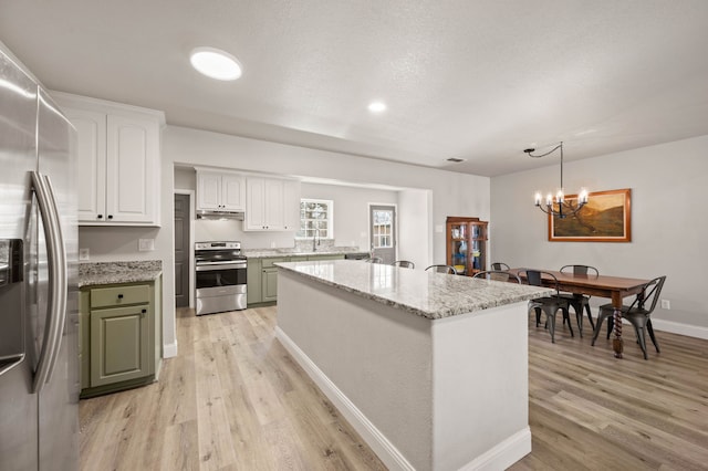 kitchen with white cabinetry, appliances with stainless steel finishes, light wood-style floors, and under cabinet range hood