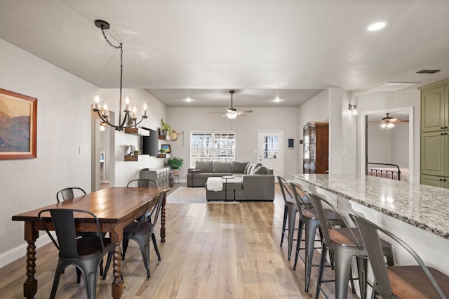 dining area featuring light wood-style floors, ceiling fan with notable chandelier, baseboards, and recessed lighting