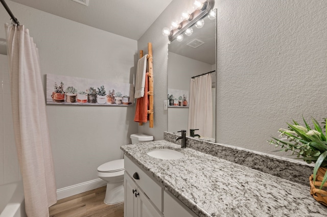 bathroom with vanity, visible vents, toilet, and wood finished floors