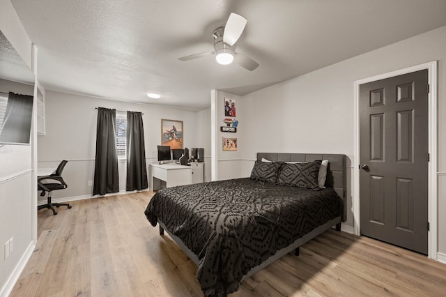 bedroom with light wood-style floors, ceiling fan, and baseboards