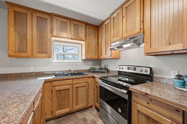 kitchen with under cabinet range hood, light countertops, stone finish floor, electric stove, and a sink