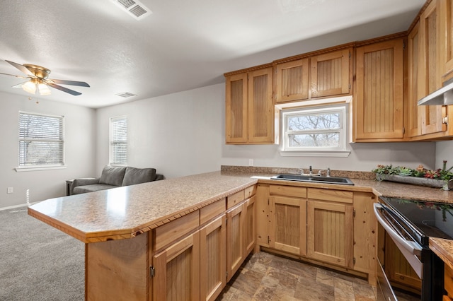 kitchen with light countertops, electric stove, a ceiling fan, a sink, and a peninsula