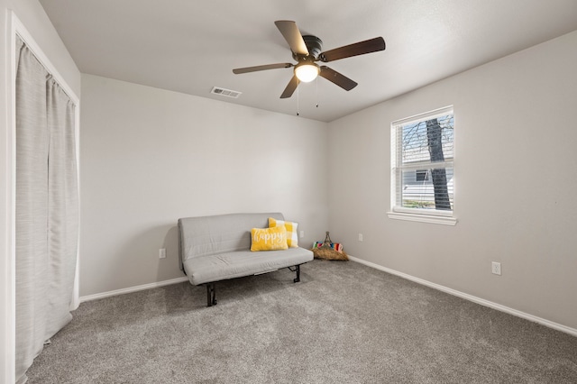 sitting room with visible vents, carpet flooring, baseboards, and ceiling fan