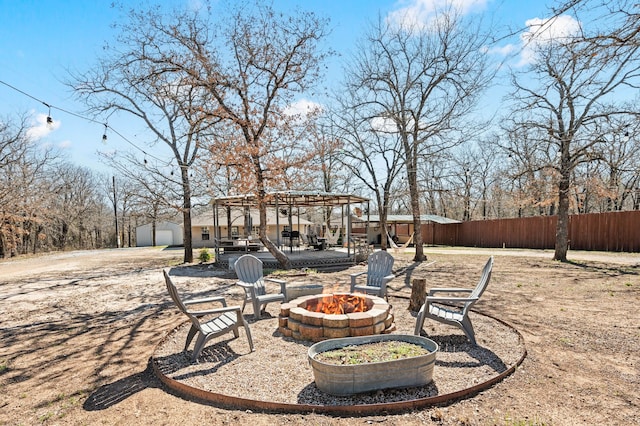 view of yard with a pergola, a shed, an outdoor fire pit, an outdoor structure, and fence