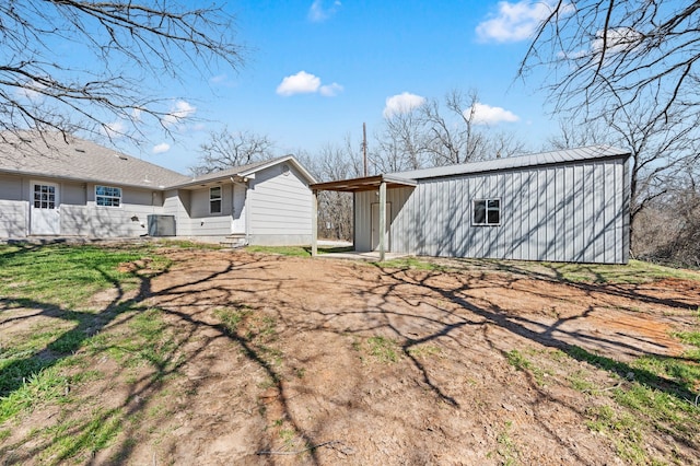 back of property featuring an outdoor structure and central AC