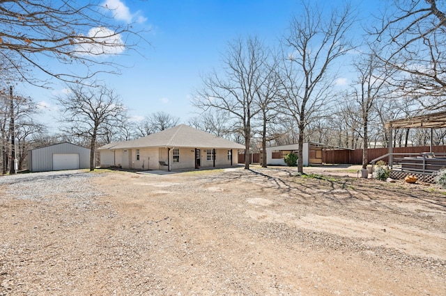 view of front facade featuring a garage, an outdoor structure, and dirt driveway