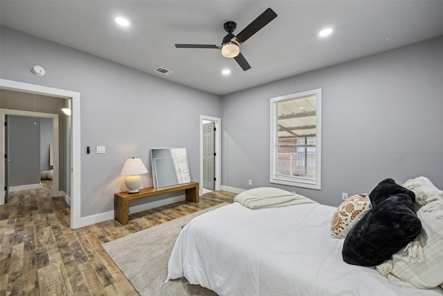 bedroom with recessed lighting, attic access, baseboards, and wood finished floors