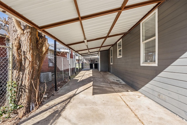 view of patio / terrace featuring an attached carport, driveway, and fence