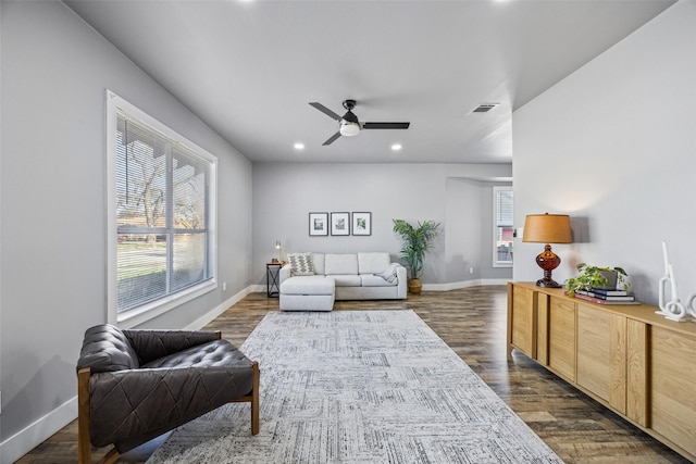 living area featuring dark wood-type flooring, plenty of natural light, baseboards, and visible vents