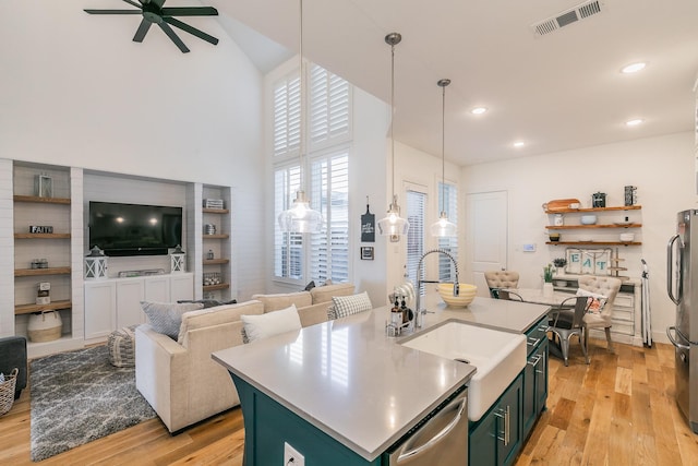 kitchen with visible vents, a sink, light wood-style floors, appliances with stainless steel finishes, and green cabinets