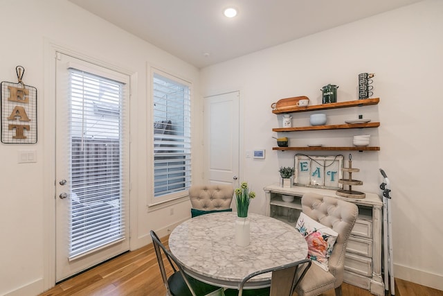 dining room featuring light wood-style flooring and baseboards