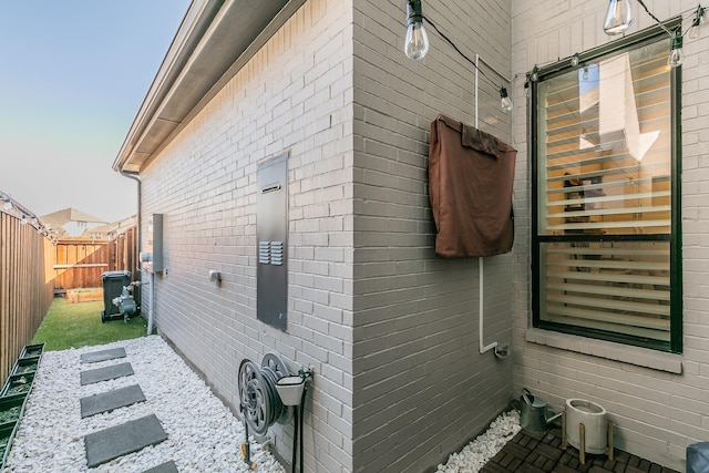 view of home's exterior with brick siding and fence