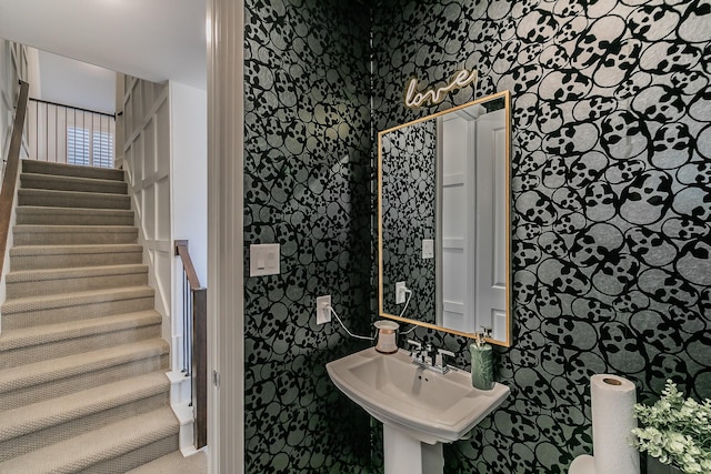 bathroom with wallpapered walls and a sink