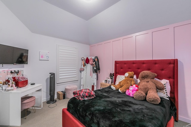 carpeted bedroom with a decorative wall and lofted ceiling