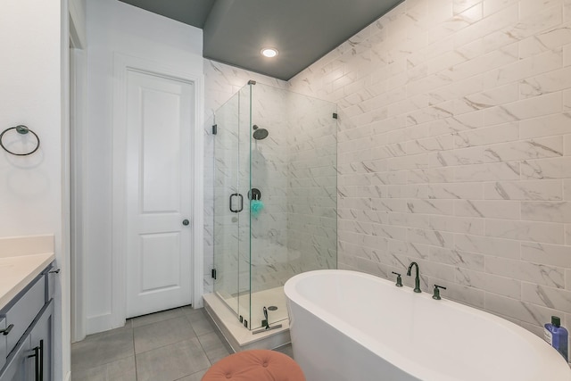 full bath with vanity, a soaking tub, a stall shower, and tile patterned floors