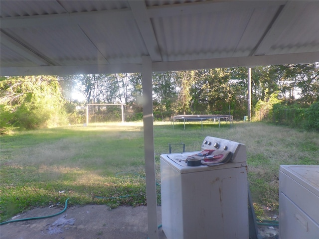 view of yard with washer and dryer and a trampoline