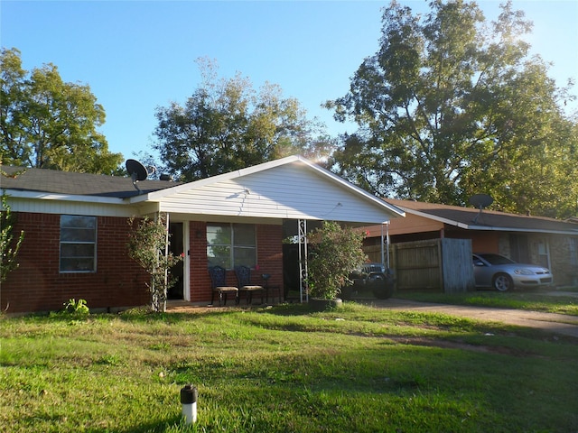 view of front facade with an attached carport, brick siding, and a front lawn