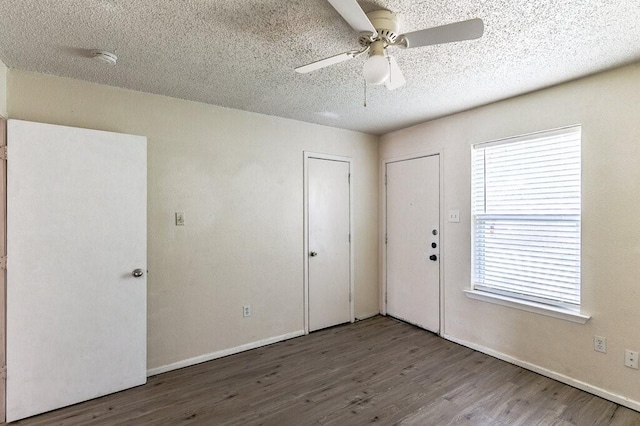 interior space with a ceiling fan, wood finished floors, baseboards, and a textured ceiling