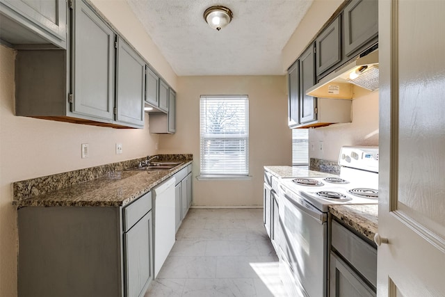 kitchen featuring marble finish floor, gray cabinets, under cabinet range hood, a sink, and white appliances