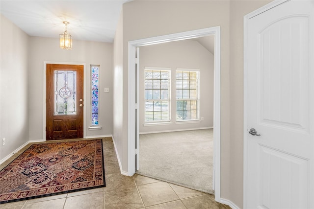 entryway featuring light tile patterned flooring, light colored carpet, and baseboards