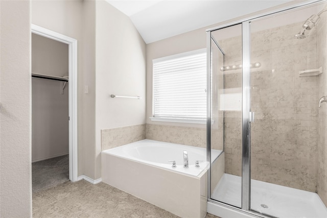 full bath featuring a shower stall, a spacious closet, a bath, and lofted ceiling