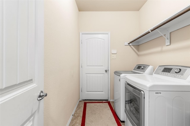 washroom with baseboards, washing machine and dryer, and laundry area