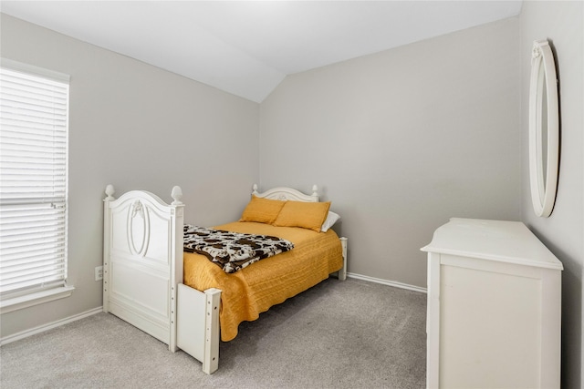 bedroom featuring light carpet, baseboards, and vaulted ceiling