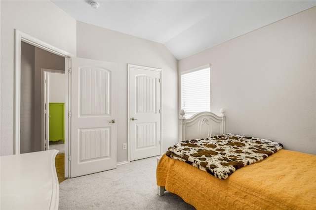 bedroom featuring a closet, light colored carpet, and vaulted ceiling