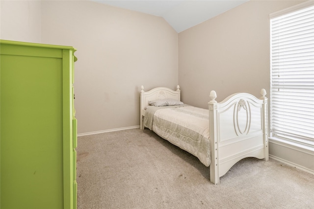 bedroom featuring baseboards, carpet, and vaulted ceiling