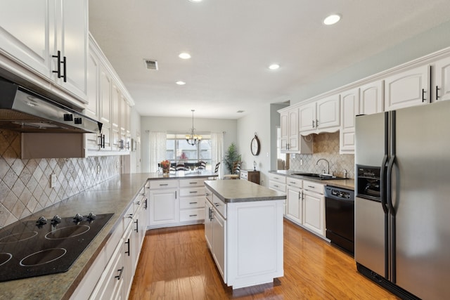 kitchen featuring black appliances, light wood-style flooring, a sink, white cabinetry, and a peninsula