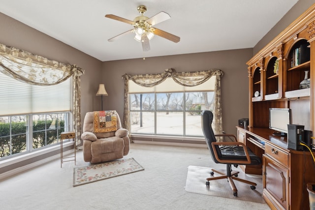 carpeted office space with a ceiling fan