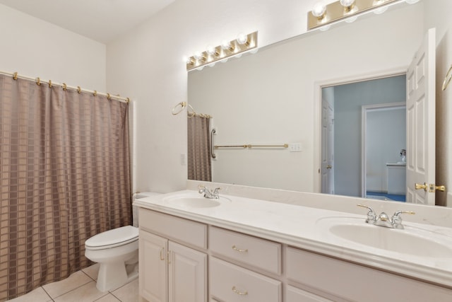 bathroom featuring a sink, toilet, double vanity, and tile patterned flooring