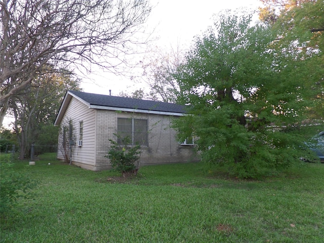 view of home's exterior with brick siding and a yard