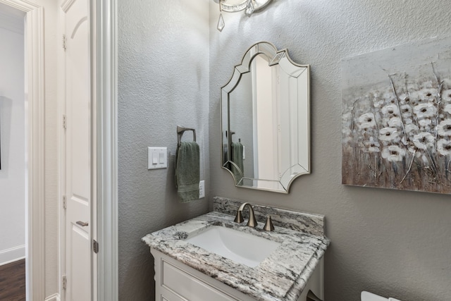 bathroom with vanity and a textured wall