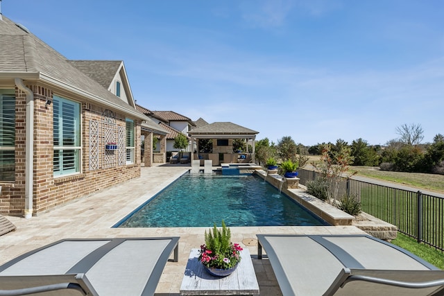 view of pool with a patio, a fenced in pool, a fenced backyard, and an in ground hot tub